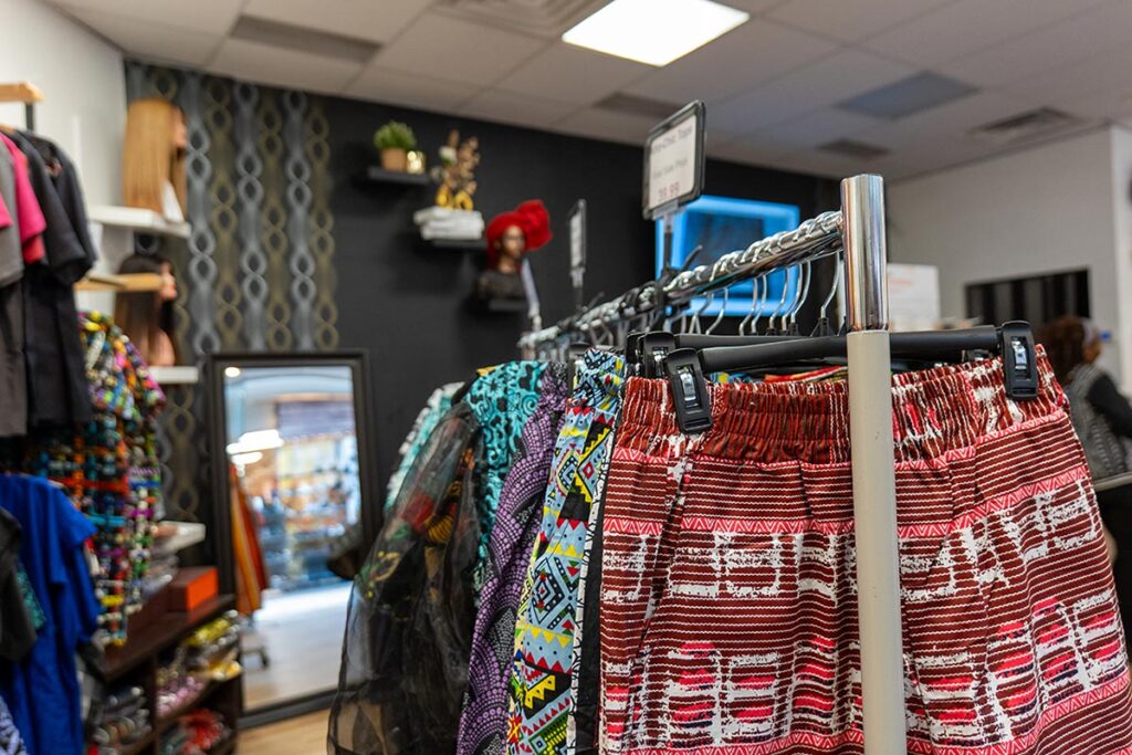 Clothing hanging from racks inside a clothing store.