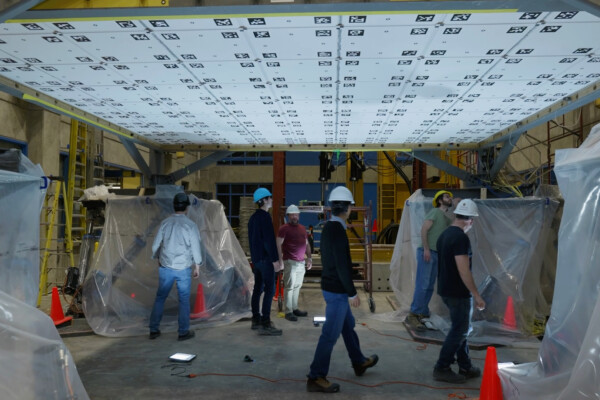 Researchers investigating the test damage caused by their earthquake simulator.