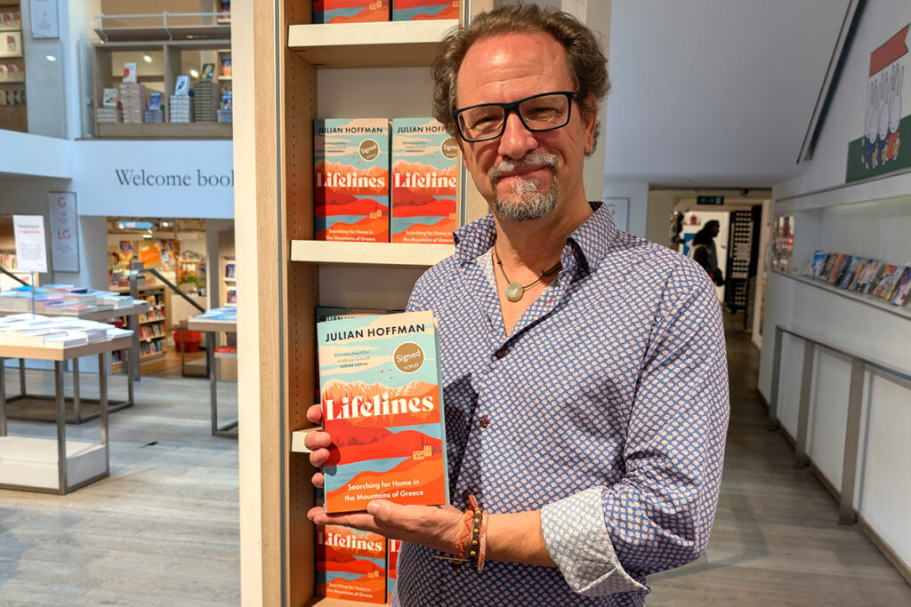 Author Julian Hoffman holding his new book about Prespa, Greece in a bookstore.