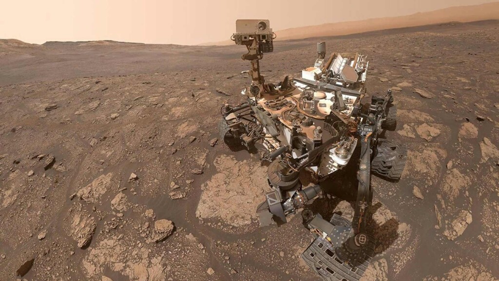 Curiosity rover on Mars surface analyzing rocks in search for signs of Mars life and organic molecules.