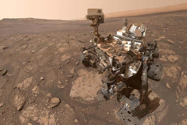 Curiosity rover on Mars surface analyzing rocks in search for signs of Mars life and organic molecules.