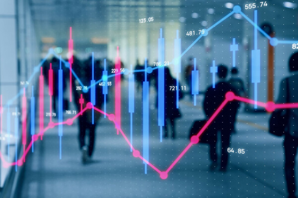 Silhouettes of people walking with stock market indicators overlayed on top.