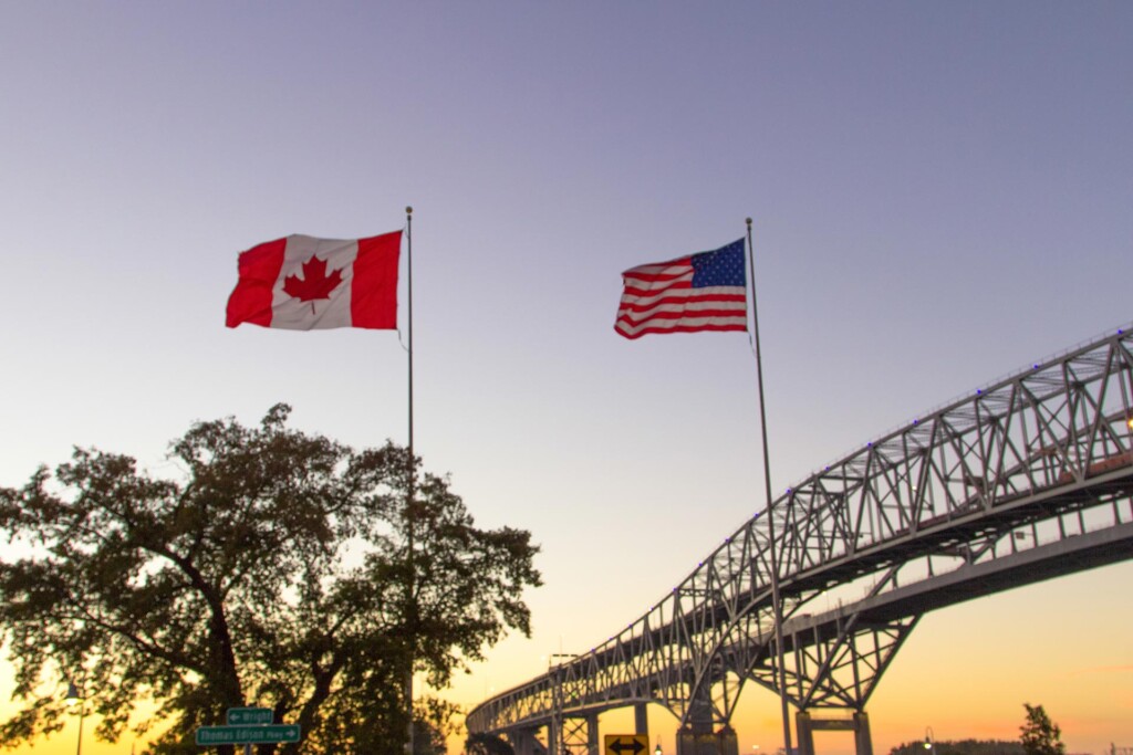 Flags of Canada and the USA, with the Blue Water Bridges international in the background.