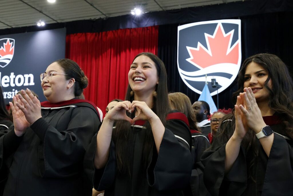 Three students in the crowd cheer at Spring Convocation.