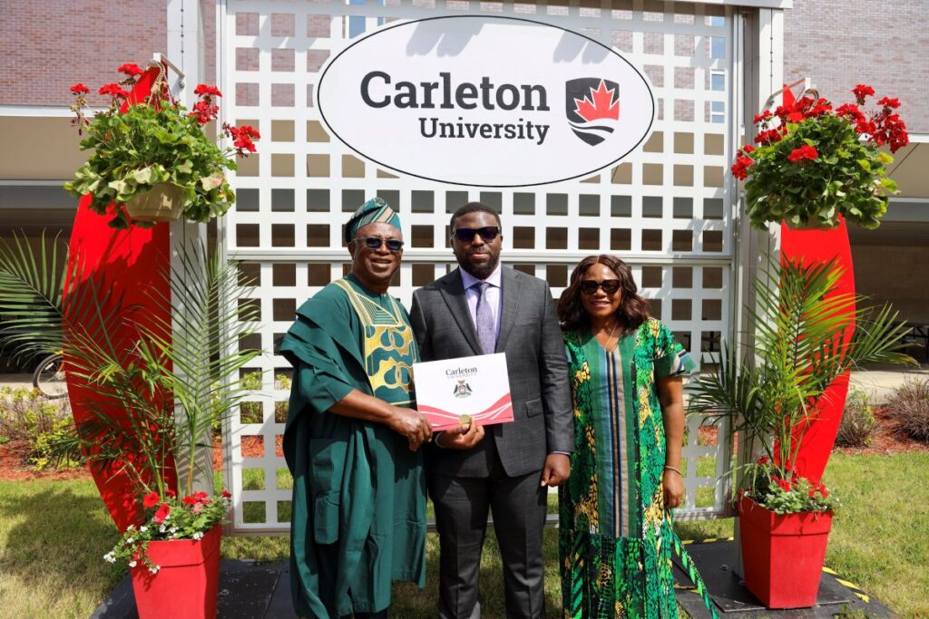 A graduating student and his supporters pose for a photo outside spring convocation 