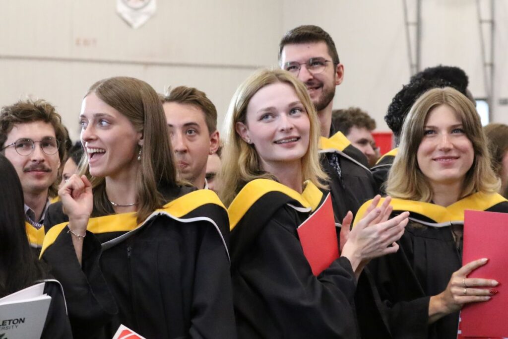 Graduating students smile and listen to speakers at Spring Convocation.