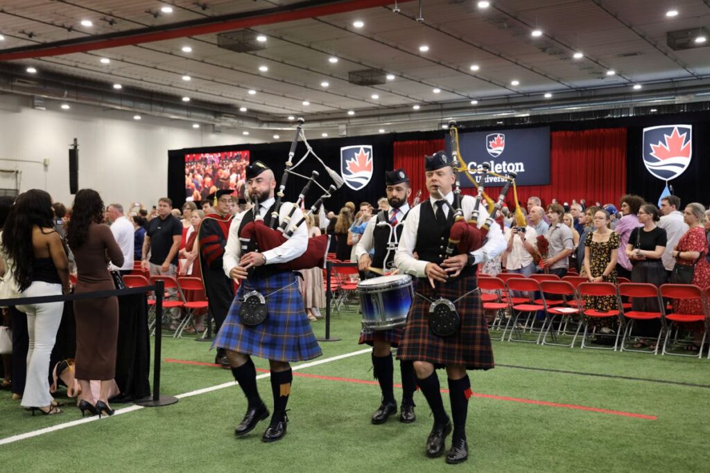 A three-person pipe bands leads faculty members into Spring Convocation.
