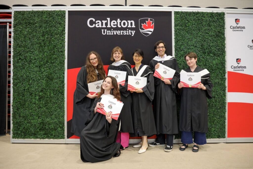 Six graduating students pose after receiving their degrees.