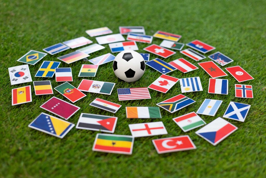 Flags of the World Cup surrounding a soccer ball on a soccer field.