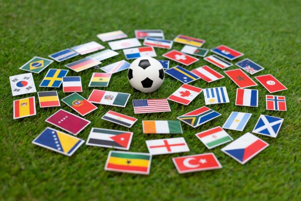 Flags of the World Cup surrounding a soccer ball on a soccer field.