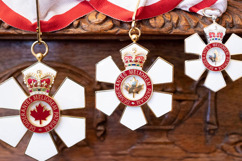 3 Order of Canada insignias hanging from a ribbon.