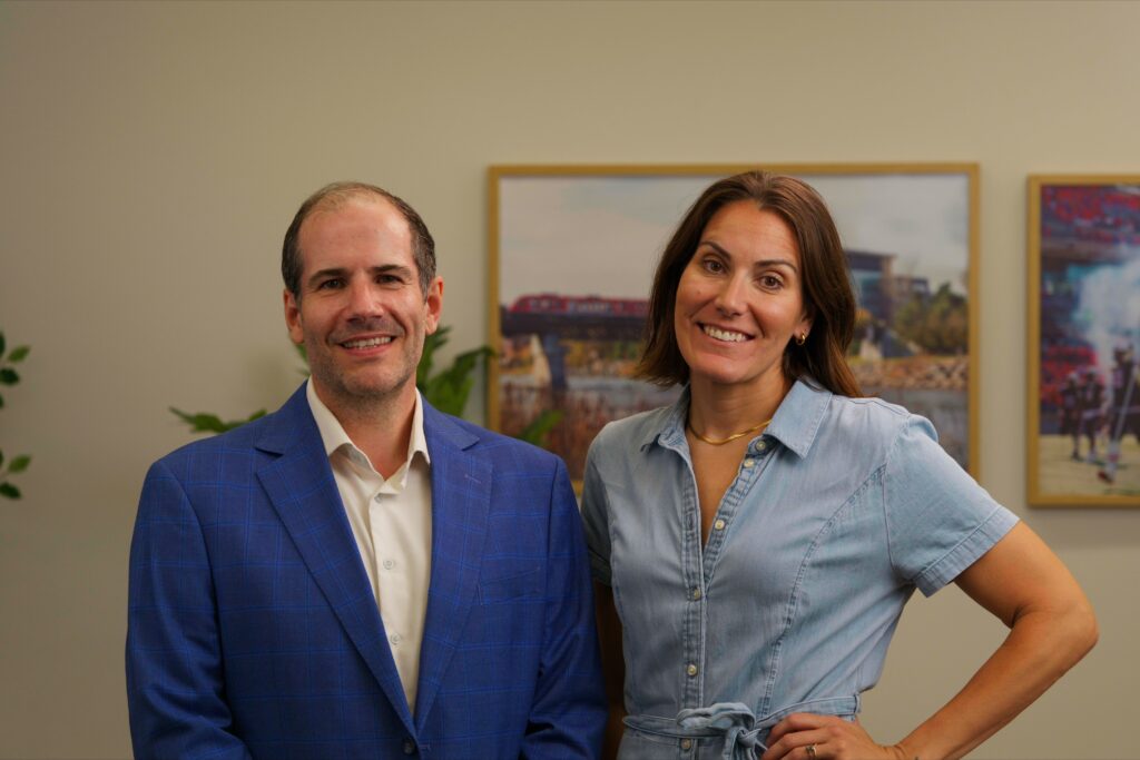 Two people wearing blue clothing posing for a photo.