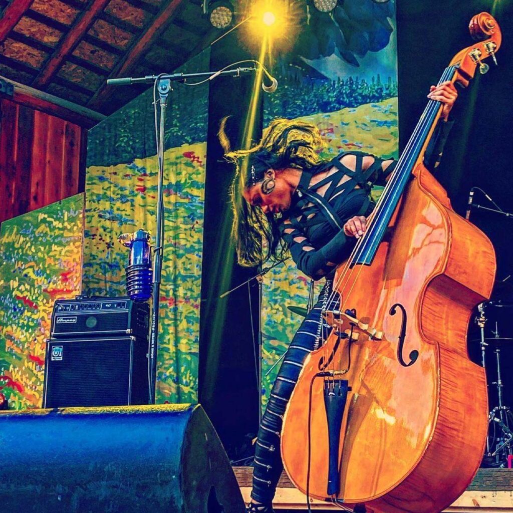 A woman plays a cello on stage.
