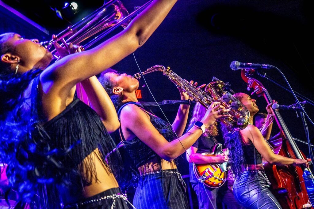 Three musicians performing for an audience.