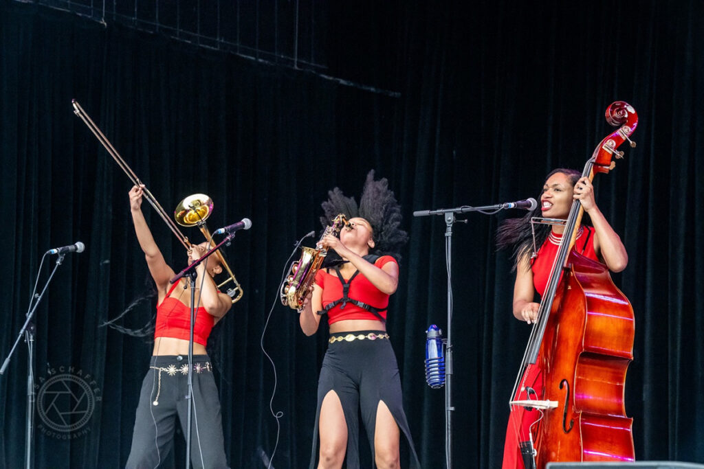 Three musicians, playing a trombone, saxophone and cello, respectively.