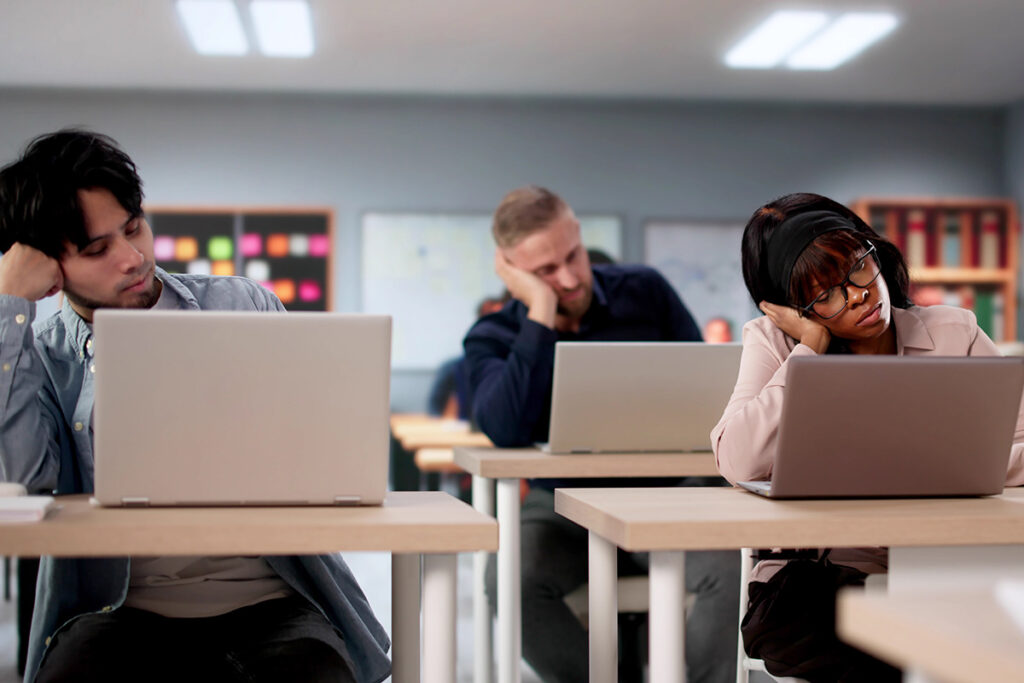 Several students working on laptops inside a classroom.