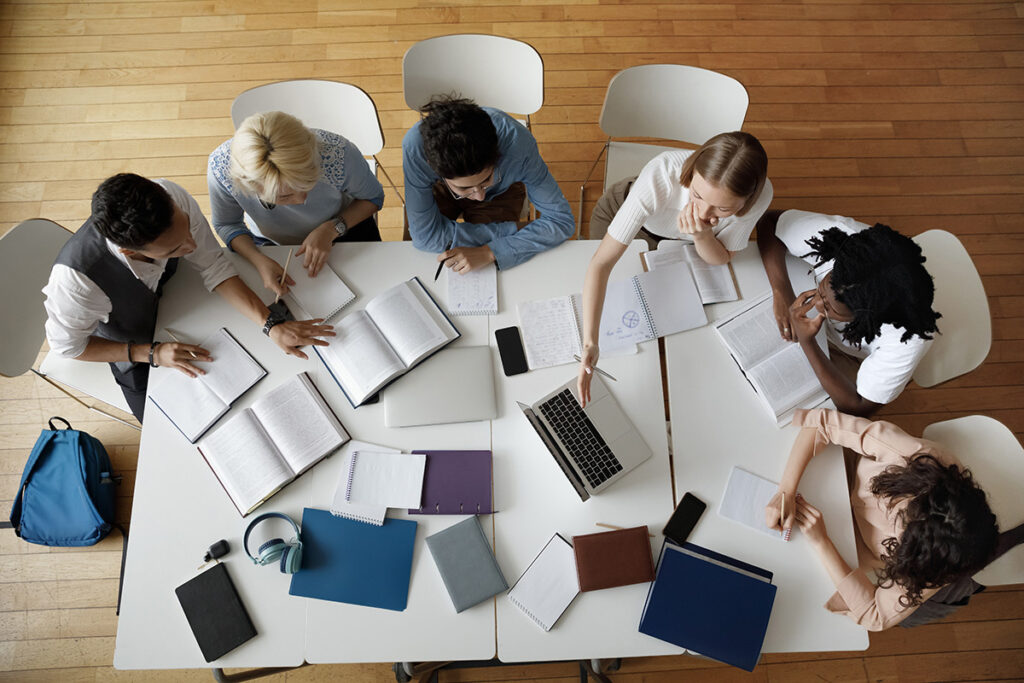 A bird's eye view of several students working together at a large table.