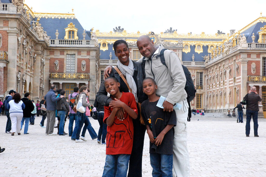 Heather Greenwood Davis and her family pose in front of the Palace of Versailles in France.
