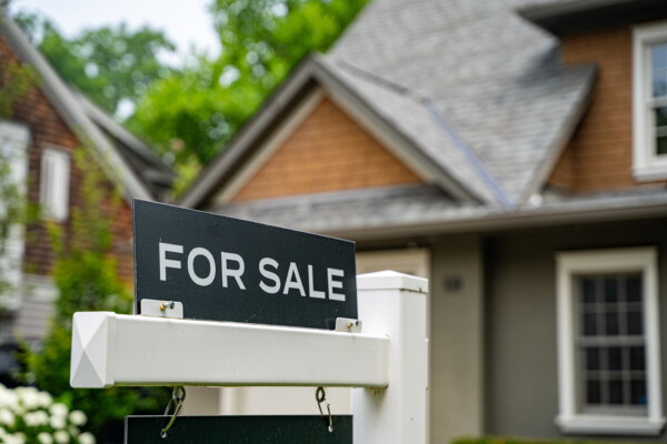 A For Sale sits in front of a home./