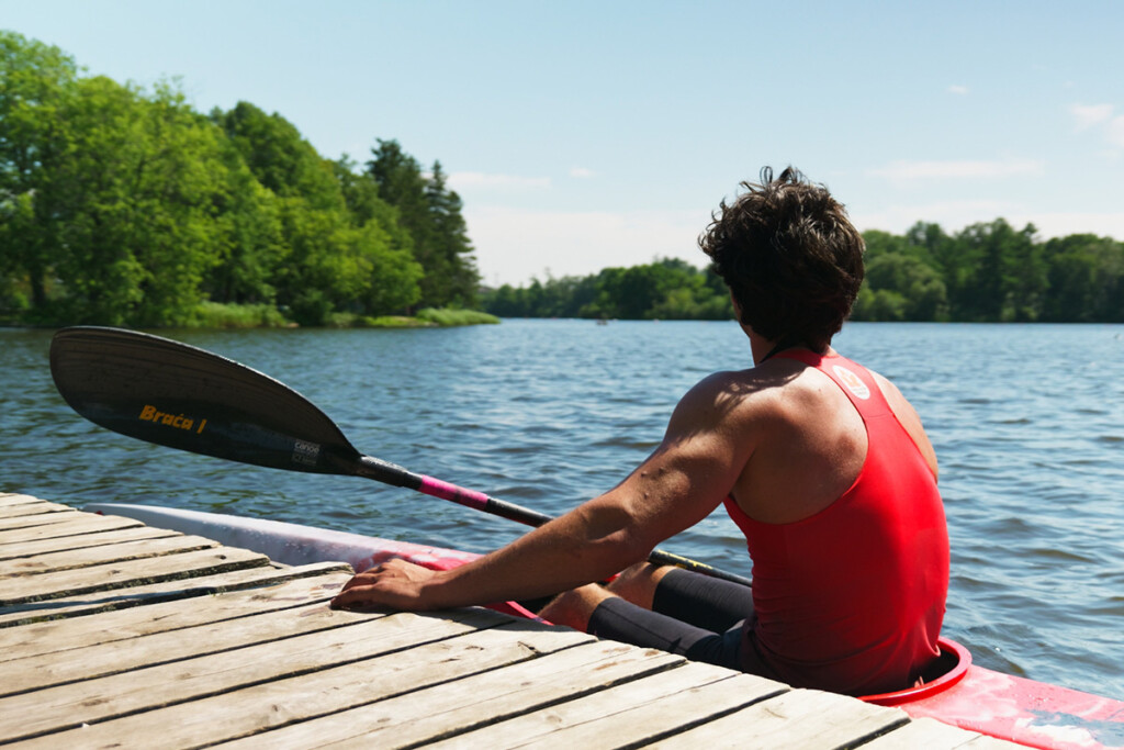 A man sitting in a kayak looking out at the water.