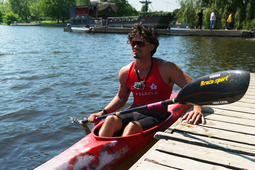 A man sitting in a kayak while leaning against a dock.