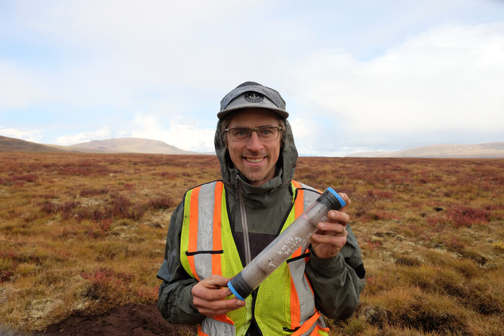 Researcher holding permafrost core sample.