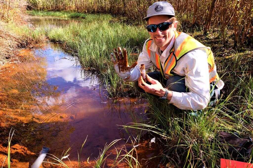 Researcher using auger to collect permafrost soil samples.
