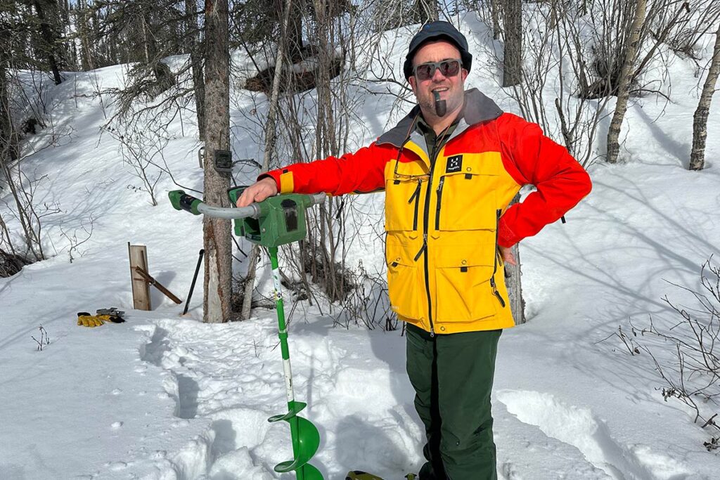 Researcher using auger to collect permafrost soil samples.