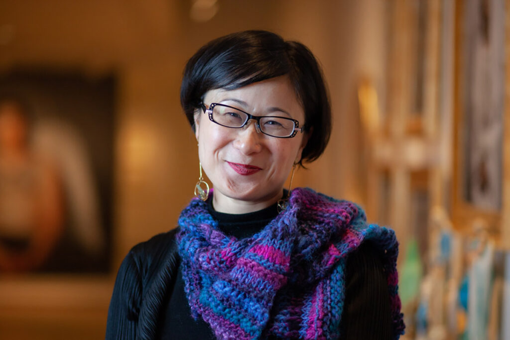 Ming Tiampo wearing glasses and a colourful scarf.