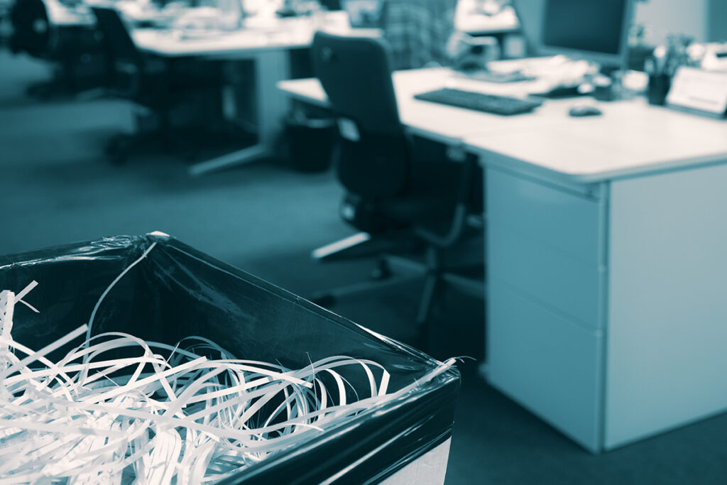 A garbage can filled with shredded documents.
