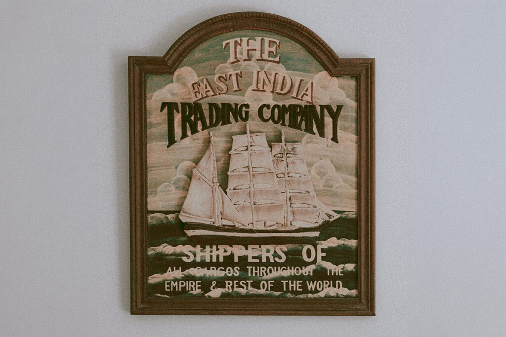 Retro wooden sign showcasing the historic East India Trading Company with ship illustration.