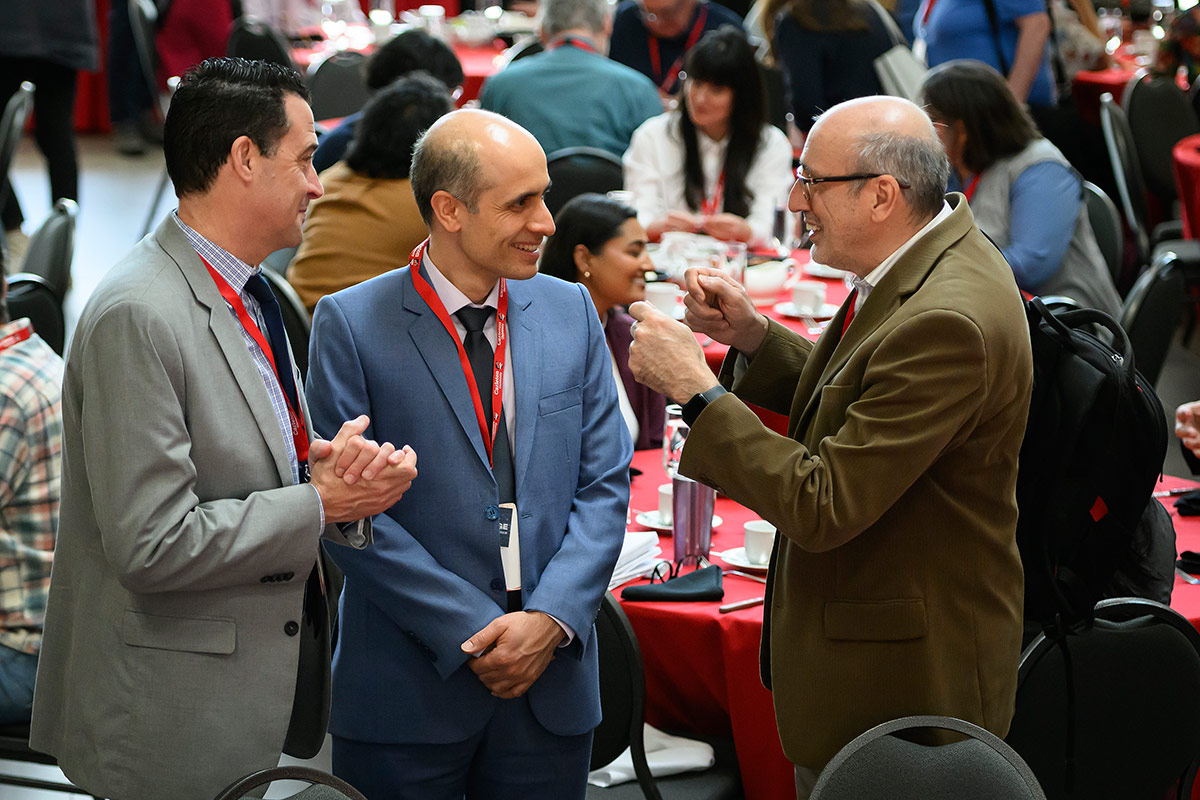 Three people in suits having an animated discussion.