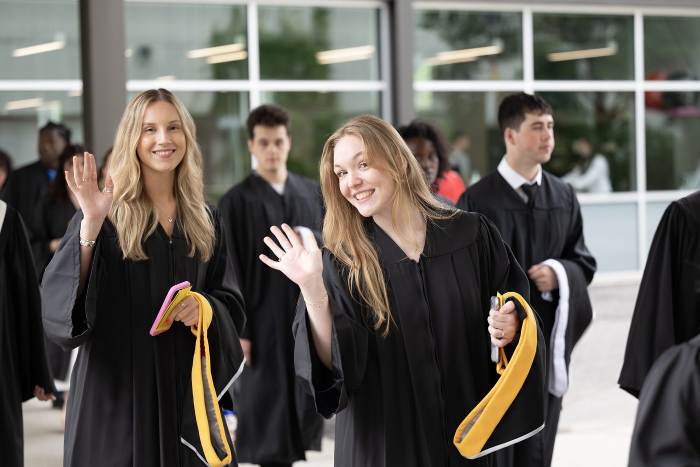Students wave as they enter Alumni Hall for convocation.