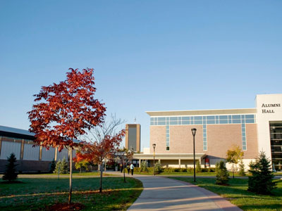 Trees line the pathway leading to Carleton's Athletics building.
