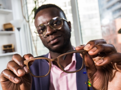 Nana Osei holds a pair of his sustainable glasses.