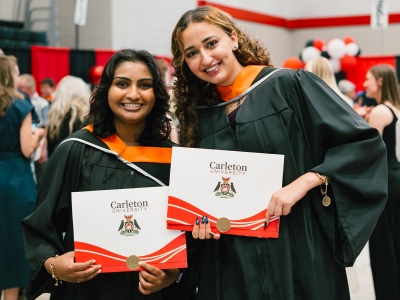 Two graduating students pose for a photo after convocation.