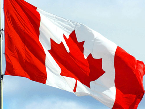 A Canadian flag waves in the wind.