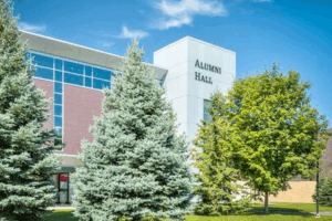 building with name Alumni Hall on the top with trees in front