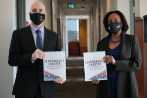 Carleton President Benoit-Antoine Bacon and Ikram Jama, interim associate vice-president and university advisor, Equity and Inclusive Communities, hold copies of the Scarborough Charter