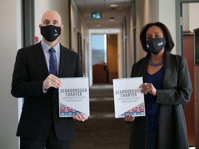 Carleton President Benoit-Antoine Bacon and Ikram Jama, interim associate vice-president and university advisor, Equity and Inclusive Communities, hold copies of the Scarborough Charter