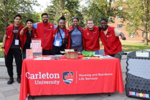 Group of students and staff standing at a welcome desk
