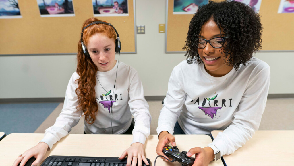The developers of Dadirri play their game on a computer keyboard amd game controller.