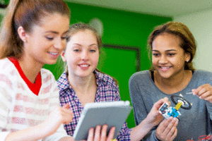 Three girls work on a school project.
