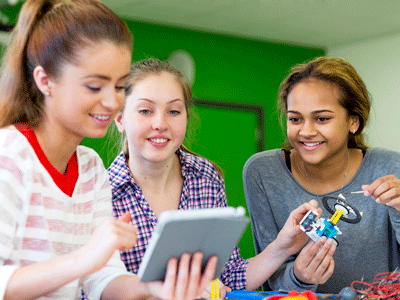 Three girls work on a school project.