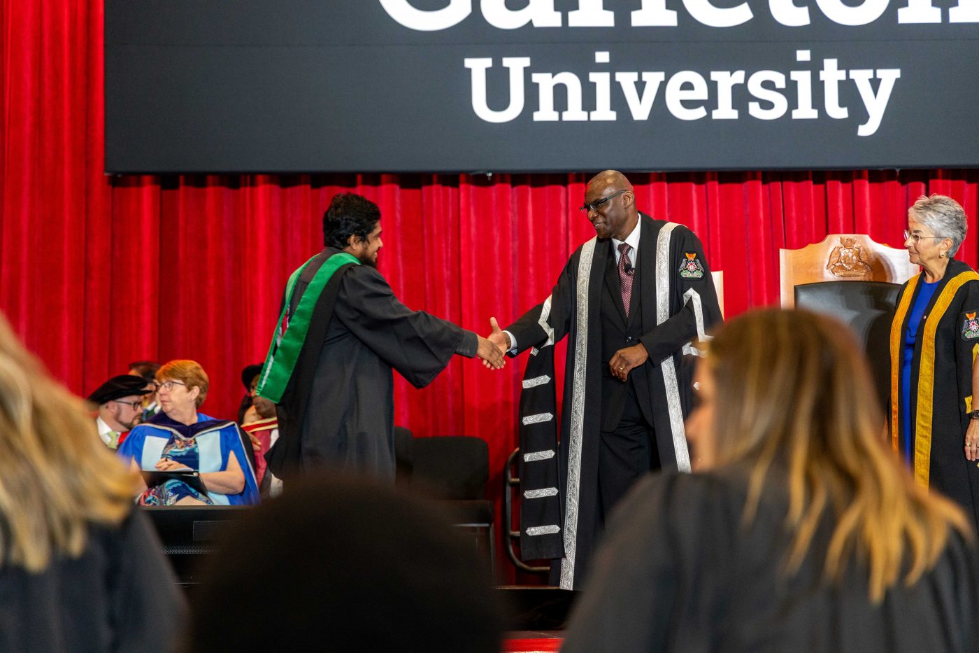 President Wisdom Tettey shakes a graduate's hand at convocation.