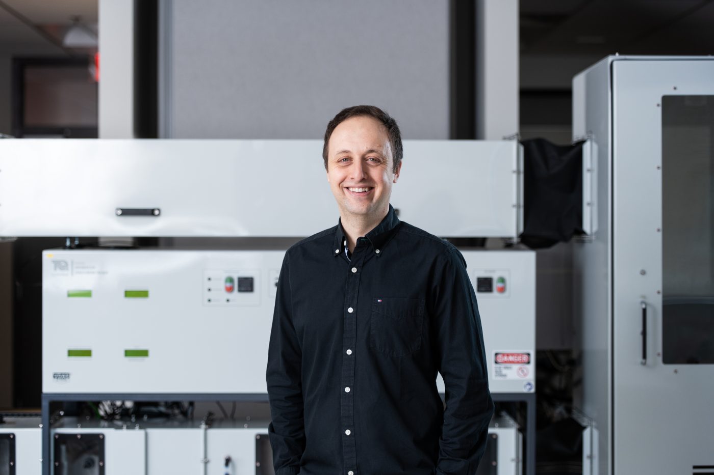 Man standing in front of equipment in engineering lab