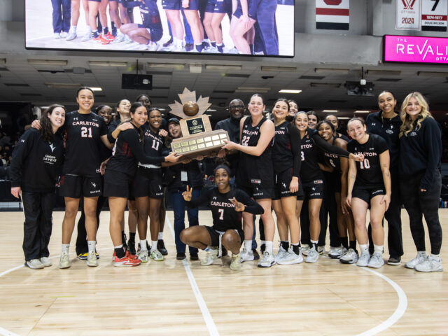 Women's basketball players pose with the Capital Hoops Trophy.