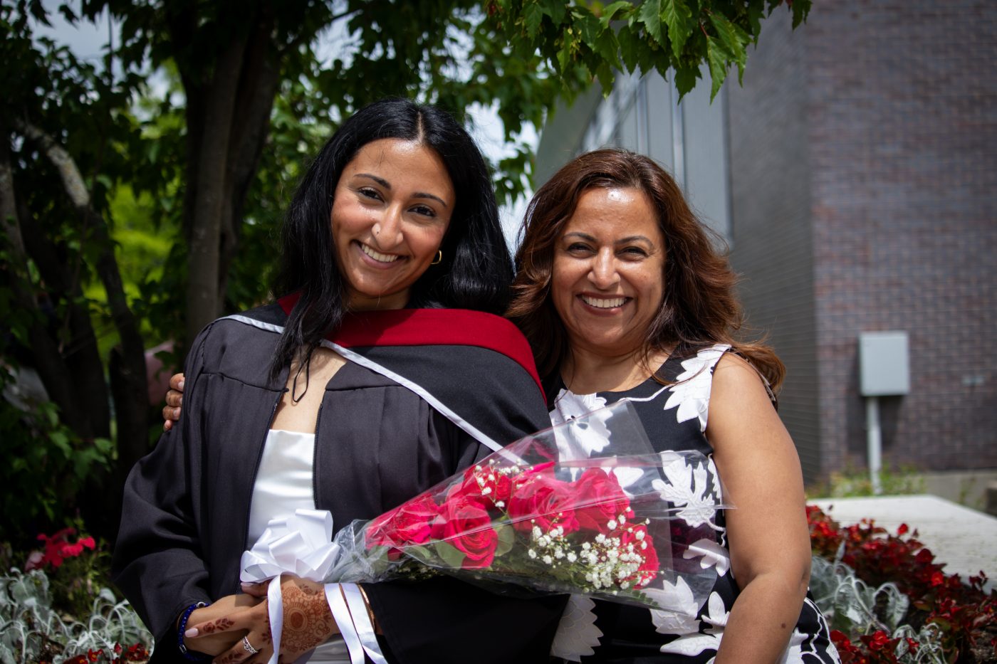 A student and her supporter smile as they pose for a photo.