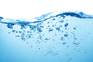 A wave of water contains bubbles under the surface.