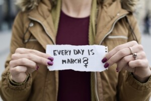 A woman holds a paper that reads 